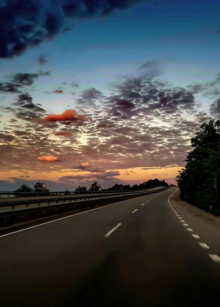 Serene highway scene with a stunning sunset sky, perfect for travel themes.